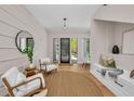 Bright foyer features light hardwood floors, textured accent wall, modern lighting and a sleek front door at 2425 Floyd St, Sarasota, FL 34239