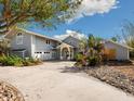 Two-story home with a light gray exterior, attached garage, and paved driveway at 4865 Featherbed Ln, Sarasota, FL 34242