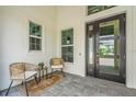 Cozy front porch featuring comfortable seating and a stylish entrance with a modern glass door at 8332 Sea Glass Ct, Sarasota, FL 34240