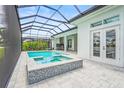 Inviting screened-in pool and spa, featuring a tiled facade with an outdoor kitchen and covered patio at 8332 Sea Glass Ct, Sarasota, FL 34240