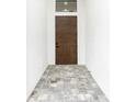 Modern entryway with a wood door and tile flooring at 14135 Carrie Ave, Port Charlotte, FL 33953