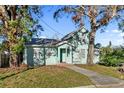Charming light teal home with a walkway and landscaping at 1501 14Th W Ave, Bradenton, FL 34205