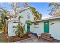 Light teal home with green door, mature trees, and parking area at 1501 14Th W Ave, Bradenton, FL 34205
