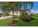 Landscaped yard with palm trees and two-car garage at 2532 Avolet Ct, Lakewood Ranch, FL 34211