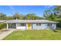 A charming ranch-style home with a yellow door and well-maintained lawn at 2877 Michigan St, Sarasota, FL 34237