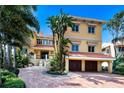 Mediterranean-style home features a brick driveway, two-car garage, and lush landscaping at 309 Ringling Point Dr, Sarasota, FL 34234