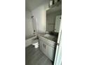 Bathroom with shower over bath, granite countertop on vanity, modern fixtures, and neutral design at 3249 Vickers Ln, North Port, FL 34286