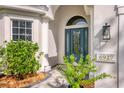 Elegant front entry with teal door and landscaping at 6927 Lennox Pl, University Park, FL 34201