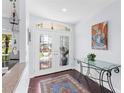 Elegant entryway with glass doors, dark hardwood floors, and a glass-top console table at 7917 Broadmoor Pines Blvd, Sarasota, FL 34243