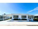 Front view of a white manufactured home with a carport and landscaping at 8 White Oak Ter, Sarasota, FL 34237