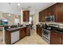 Kitchen with an island, stainless steel appliances, and dark wood cabinets at 8277 Villa Grande Ct, Sarasota, FL 34243