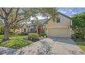 Tan house with red door, mature trees, and a basketball hoop at 9506 Royal Calcutta Pl, Lakewood Ranch, FL 34202