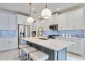Modern kitchen with white cabinets, large island, and quartz countertops at 10180 Canaveral Cir, Sarasota, FL 34241