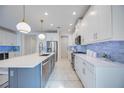 Modern kitchen with white cabinets, large island, and quartz countertops at 10180 Canaveral Cir, Sarasota, FL 34241