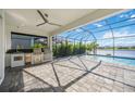 Outdoor kitchen, screened patio, and pool overlooking lake at 10180 Canaveral Cir, Sarasota, FL 34241