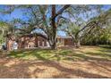 Large backyard with mature oak trees and a deck at 1616 North Dr, Sarasota, FL 34239