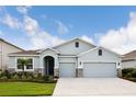 Two-story house with light gray siding, stone accents, and a two-car garage at 16926 Harvest Moon Way, Bradenton, FL 34211