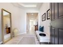 Bright and airy entryway with tile flooring, bench seating and large mirror at 16926 Harvest Moon Way, Bradenton, FL 34211