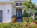 Elegant home entrance featuring a beautifully landscaped walkway and decorative double doors at 5058 Surfside Cir, Lakewood Ranch, FL 34211