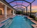 Stunning screened pool with waterfall features and tranquil water views at sunset at 5058 Surfside Cir, Lakewood Ranch, FL 34211