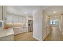 Modern kitchen with white cabinets, stainless steel appliances, and tile backsplash at 5760 Midnight Pass Rd # 307D, Sarasota, FL 34242