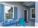 Front porch with teal chair and metal bench, providing a welcoming entrance at 14607 Barefoot Ln, Parrish, FL 34219