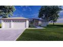 Two-car garage and front entrance of a single-story home with landscaping at 24480 Cabana Rd, Punta Gorda, FL 33955