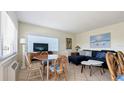 Living room with a sectional sofa, round table, and TV at 475 Benjamin Franklin Dr # 209, Sarasota, FL 34236