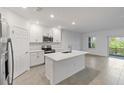 Open concept kitchen with island, white cabinetry, and stainless steel appliances at 5732 Tripoli Dr, Palmetto, FL 34221