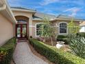 Inviting front entry with brick walkway and lush landscaping at 6828 Coyote Ridge Ct, University Park, FL 34201