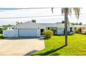 Updated home exterior featuring a modern garage and well-maintained lawn at 177 N Waterway Nw Dr, Port Charlotte, FL 33952