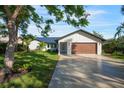 Modern home exterior with a wood-paneled garage door and well-manicured lawn at 1899 Buccaneer Cir, Sarasota, FL 34231