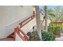 Exterior condo staircase with wooden railings and tropical plants at 304 Spring Lakes Blvd # 304, Bradenton, FL 34210