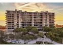 Stunning beachfront condo building at sunset, showcasing architectural details at 415 L Ambiance Dr # C403, Longboat Key, FL 34228