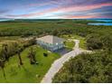 Elevated view of a house with a large yard and surrounding nature at 445 Horseshoe Loop Rd, Terra Ceia, FL 34250