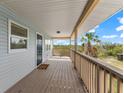 Covered porch with wooden deck, offering scenic views of nature at 445 Horseshoe Loop Rd, Terra Ceia, FL 34250