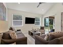 Living room with vaulted ceiling, sliding glass doors and comfortable seating at 11454 Rolling Green Dr, Bradenton, FL 34211