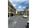 Condo building with ample parking in front and tropical landscaping at 14459 River Beach Dr # 112, Port Charlotte, FL 33953