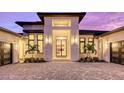 Modern home with a white stone facade, double garage doors, and palm trees at 19439 Beacon Park Pl, Bradenton, FL 34202