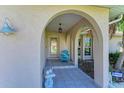 Covered front porch with seating and an arched entry at 220 Monet Dr, Nokomis, FL 34275