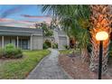 Charming exterior view of a well-maintained townhome with a lush front yard and walkway at 2208 Bahia Vista St # F3, Sarasota, FL 34239