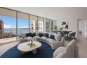 Bright living room with curved sofa, city views, and open floor plan at 301 Quay Commons # 1111, Sarasota, FL 34236