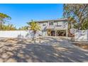 Two-story house with carport, white fence, and palm trees at 3511 Camino Real, Sarasota, FL 34239