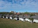Exterior view displays waterfront condos with balconies, and well-manicured landscaping with palm trees, set against a blue sky at 4234 Gulf Of Mexico Dr # Y2, Longboat Key, FL 34228