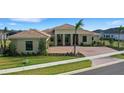 Tan house with tile roof, three-car garage, and palm trees at 4672 Mondrian Ct, Sarasota, FL 34240