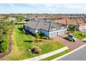 Aerial view of the house shows a well-maintained lawn and driveway, complemented by mature palm trees and landscaping at 4705 Tortona Ct, Bradenton, FL 34211