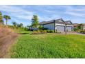 A bright and sunny exterior view showcases a spacious lawn and well-maintained landscaping at 4705 Tortona Ct, Bradenton, FL 34211