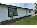 White house with black window frames and newly planted landscaping at 6593 Kenwood Dr, North Port, FL 34287