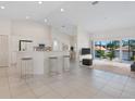 Open concept kitchen and living area with breakfast bar, white cabinetry, and access to a balcony at 7335 Fountain Palm Cir # 7335, Bradenton, FL 34203