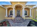 Inviting front porch with a rocking chair and decorative stonework at 118 Creek Se Dr, Port Charlotte, FL 33952